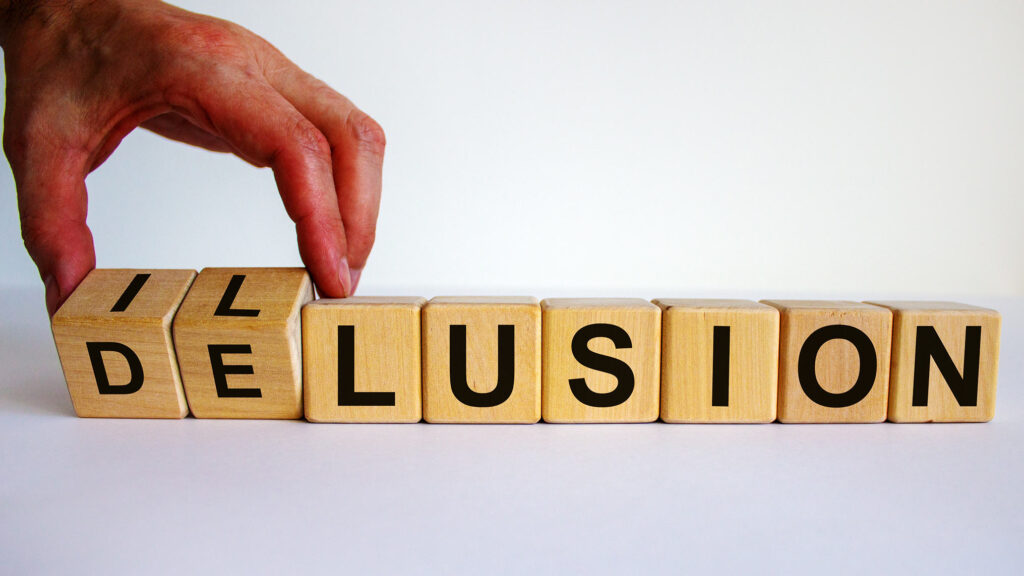 Image of letter blocks that show the simple switch of two letter blocks in between the words delusion and illusion.