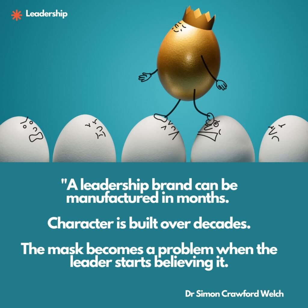 Visual description: Against a teal background, a golden egg wearing a small paper crown stands on top of a row of plain white eggs, each white egg drawn with a grumpy or scowling cartoon face. The golden egg is given sketched arms and legs and appears to balance above the crowd. The category label Leadership appears at the top left beside an orange asterisk mark.
Concept: The polished golden egg standing above a row of frowning ordinary eggs illustrates a manufactured leadership image set apart from the character beneath it, connecting to the leadership theme of the gap between brand and substance.
Quote: "A leadership brand can be manufactured in months. Character is built over decades. The mask becomes a problem when the leader starts believing it.
By Dr Simon Crawford Welch
