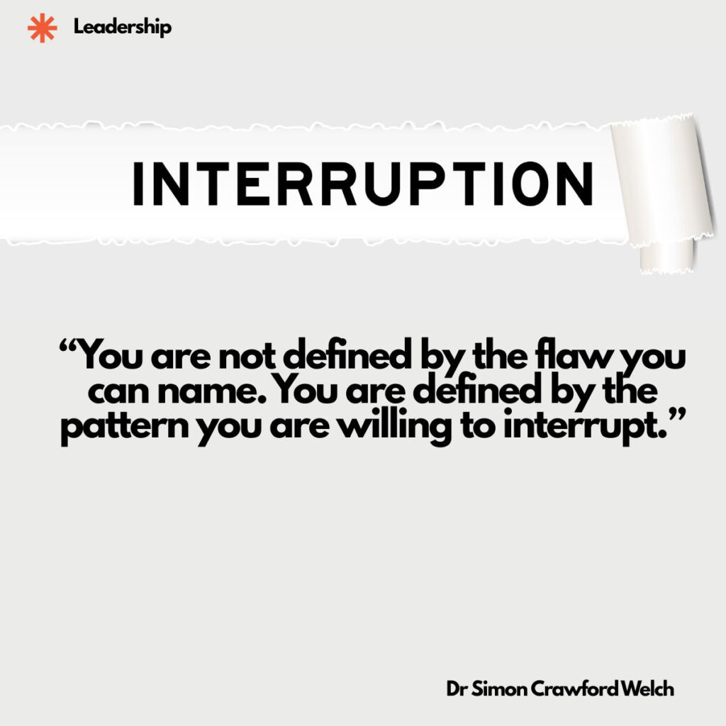 A torn strip of white paper peeling back across a pale grey background to reveal the word INTERRUPTION in bold black capital letters. The image represents the deliberate break in a pattern, the moment a familiar sequence is stopped rather than repeated. The quote over the image reads, "You are not defined by the flaw you can name. You are defined by the pattern you are willing to interrupt." By Dr Simon Crawford Welch.