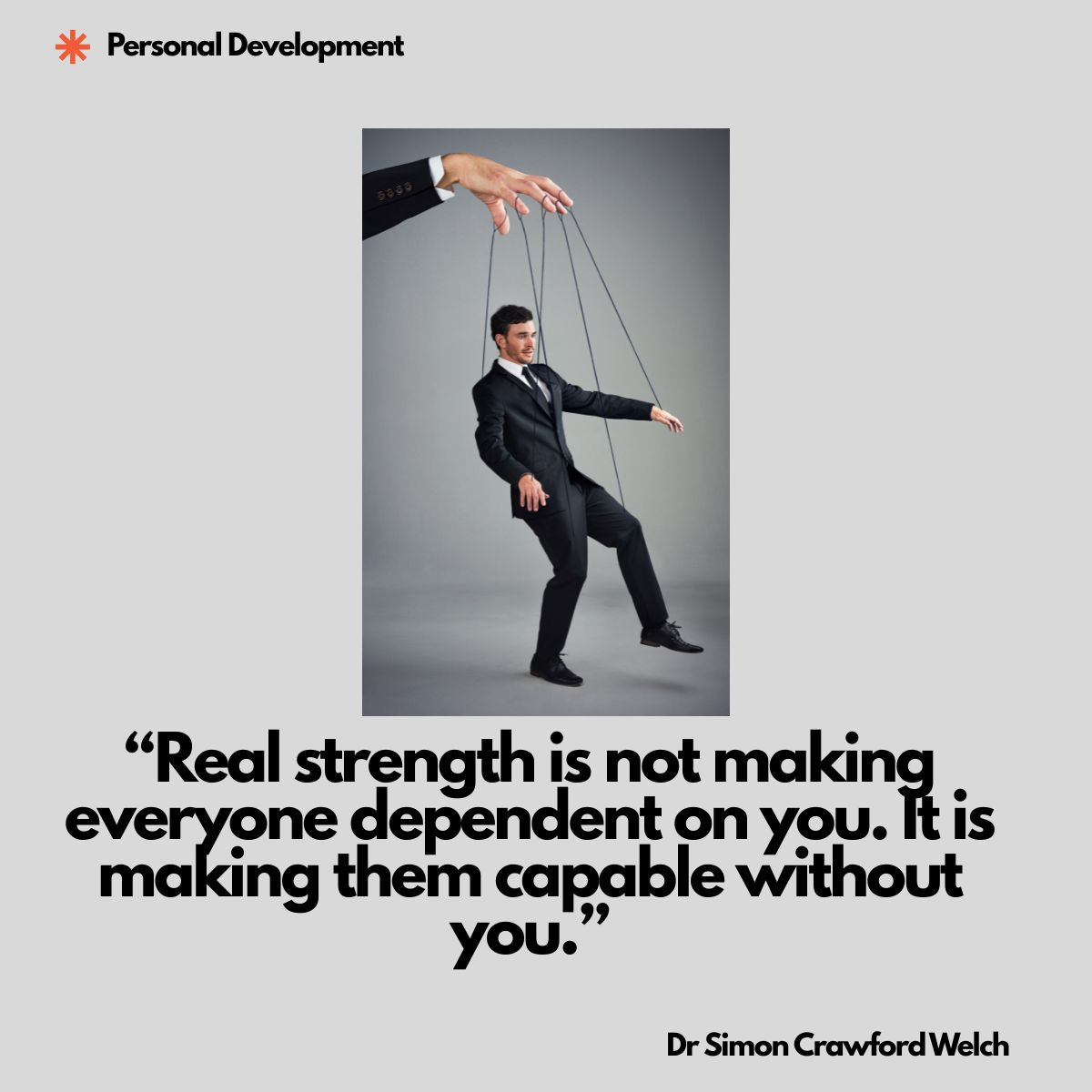 A man in a dark suit stands off balance in a grey studio while strings from a large hand above control his arms and body like a marionette. The concept is control disguised as support, showing how dependence can be created in the name of helping. Text over the image reads: "Real strength is not making everyone dependent on you. It is making them capable without you." By Dr Simon Crawford Welch.