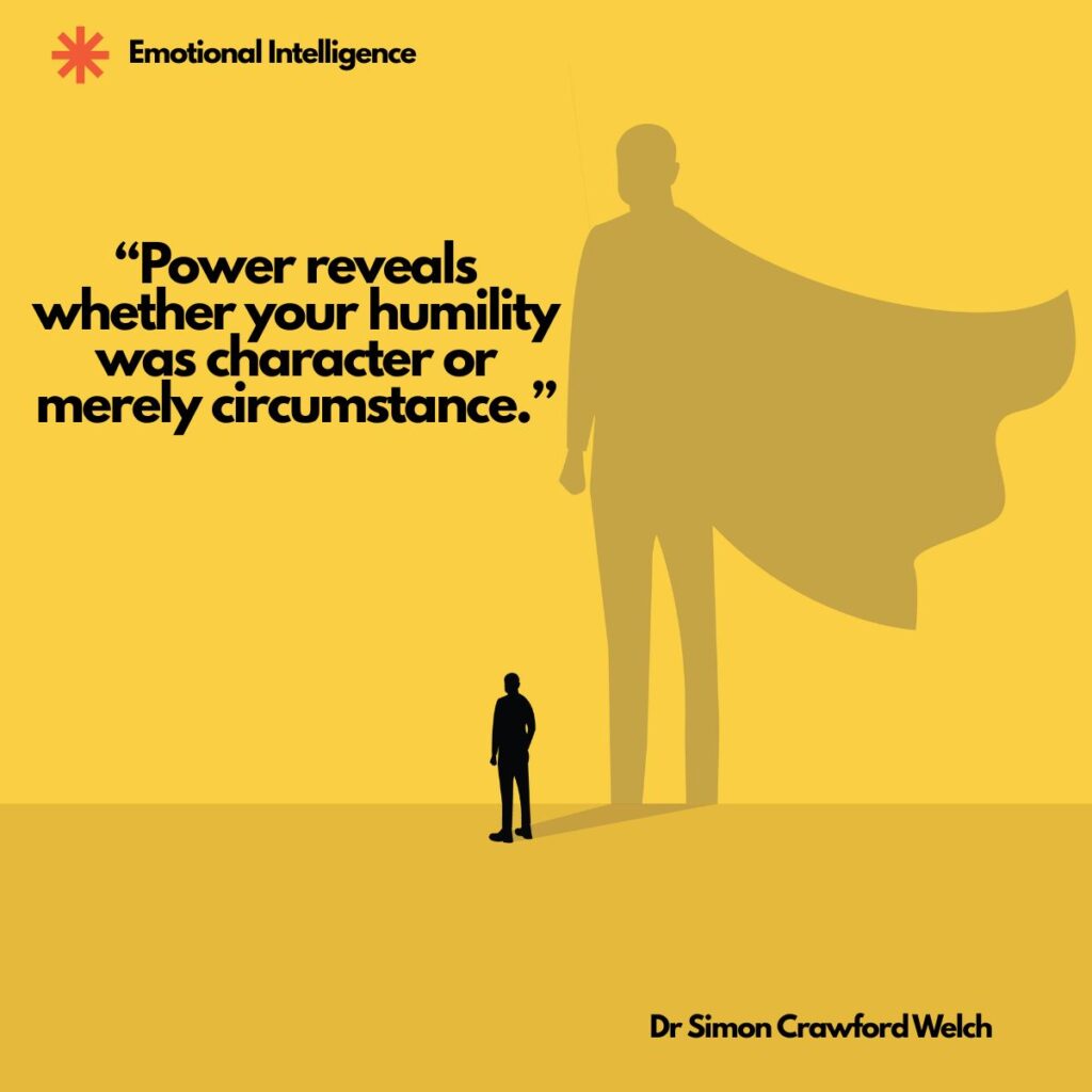A small black silhouette of a man stands on a yellow ground while his shadow rises behind him as a giant figure wearing a flowing superhero cape, with an Emotional Intelligence label in the top corner. The image represents how power enlarges whatever a person already carries inside. Quote over the image reads: "Power reveals whether your humility was character or merely circumstance." By Dr. Simon Crawford Welch.