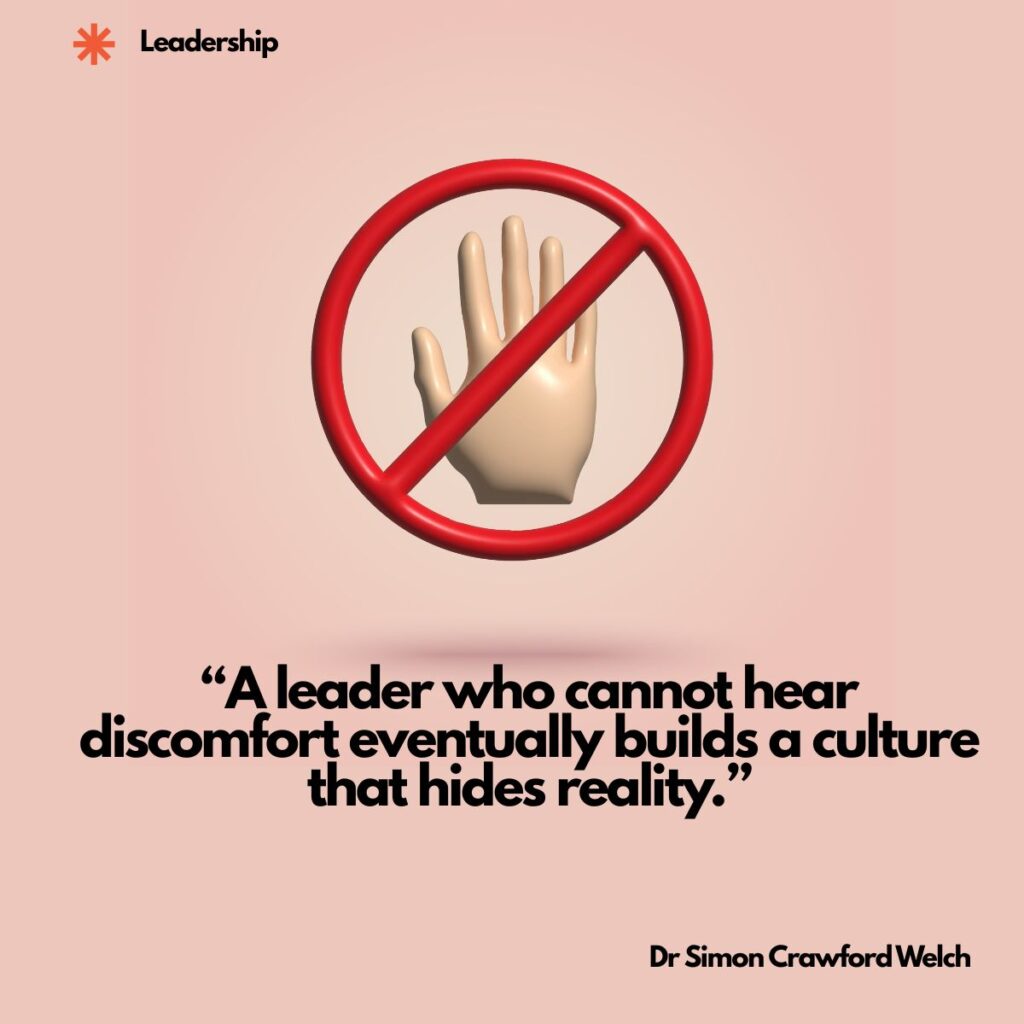 A 3D illustration of an open hand inside a red prohibition circle with a diagonal line through it, on a soft pink background, with a Leadership label in the top corner. The image represents a leader refusing to hear what is uncomfortable, and the hidden reality that refusal creates. Quote over the image reads: "A leader who cannot hear discomfort eventually builds a culture that hides reality." By Dr. Simon Crawford Welch.