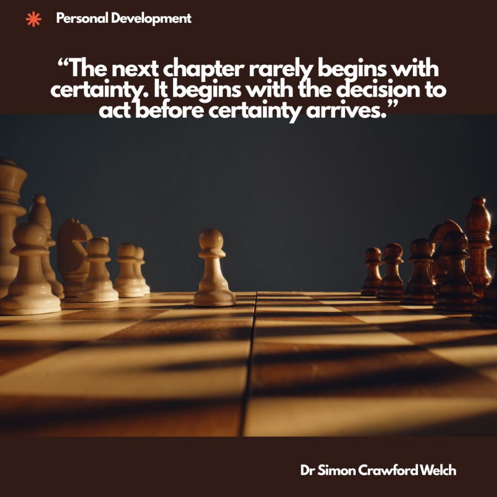 A low angle view across a wooden chessboard in warm light, with a single white pawn advanced toward the center and the other pieces waiting on either side, with a Personal Development label in the top corner. The image represents the next move that remains available even when the whole situation feels uncertain. Quote over the image reads: "The next chapter rarely begins with certainty. It begins with the decision to act before certainty arrives." By Dr. Simon Crawford Welch.