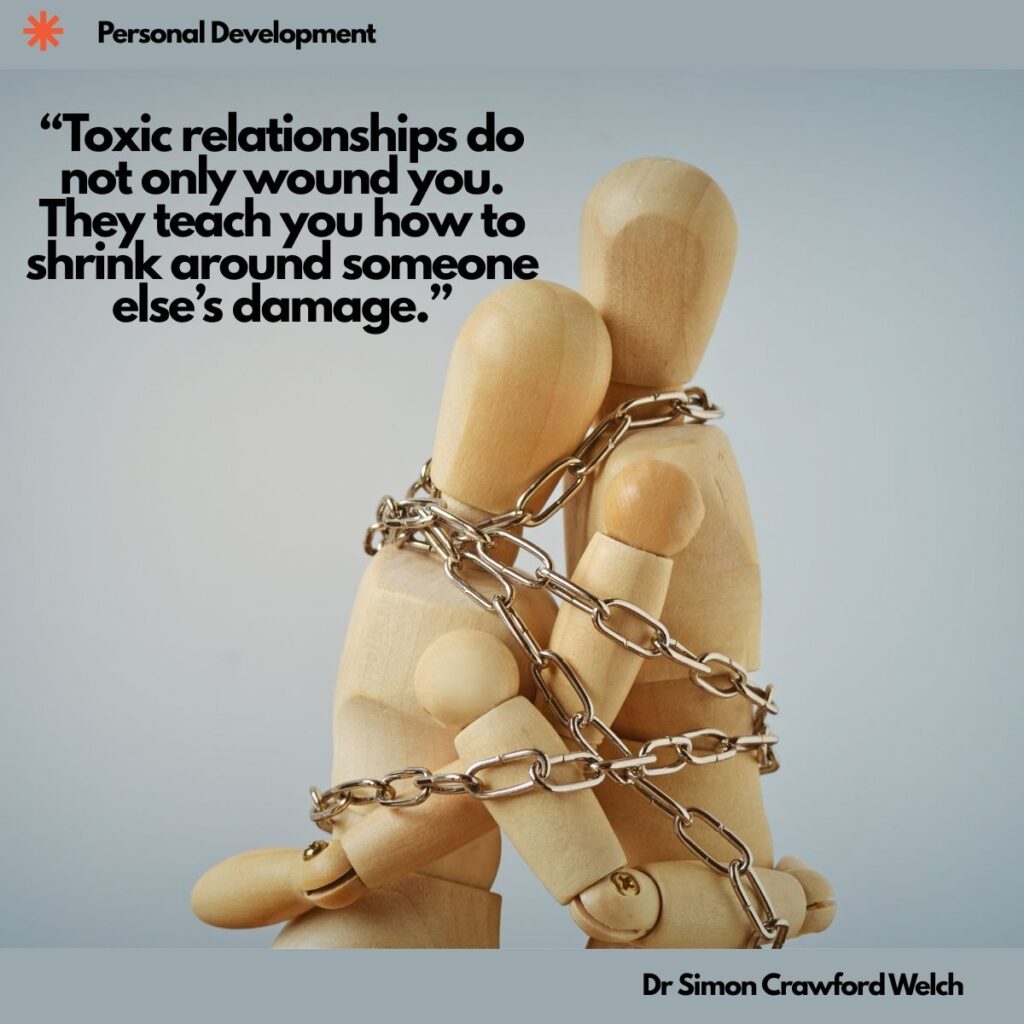 Two wooden artist mannequins sit pressed together, bound tightly by a silver metal chain wrapped around their bodies and arms, against a soft grey background, with a Personal Development label in the top corner. The image represents how a toxic relationship can bind two people together and leave one of them smaller. Quote over the image reads: "Toxic relationships do not only wound you. They teach you how to shrink around someone else’s damage." By Dr. Simon Crawford Welch.
