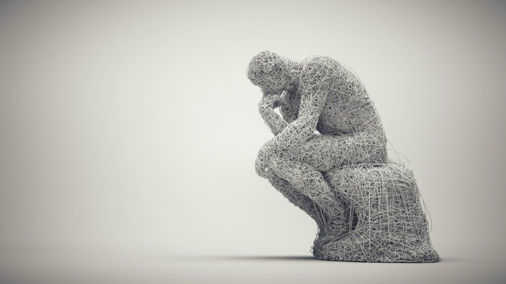 A sculpture of a seated thinker, made entirely of tangled white wire, rests its chin on its hand against a soft grey background. The image represents the quiet self-examination that power makes harder to sustain.